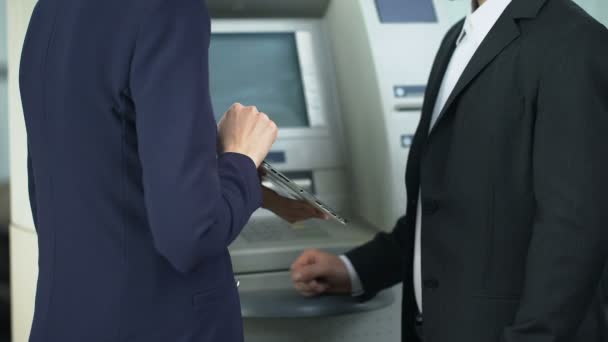 Banquero mostrando al cliente en la tableta cómo pagar la factura de servicios públicos en línea y retirar dinero en efectivo — Vídeo de stock