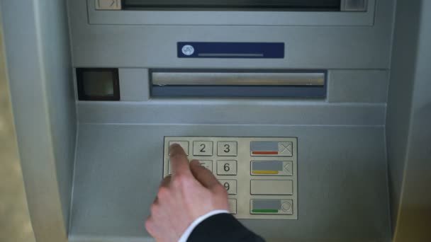 Человек исправляет пин-код на клавиатуре банкомата, переводит средства между банковскими счетами — стоковое видео