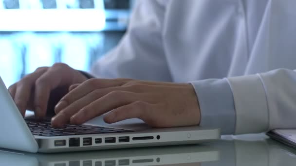 Laboratory researcher working on laptop and filling experiment report documents — Stock Video