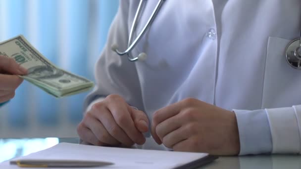 Лікар дає доларові купюри колезі і потискає руку, незаконна угода — стокове відео