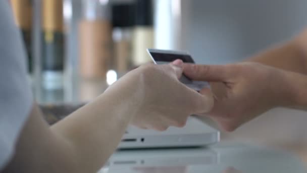 Клиент салона красоты дает кредитную карту администратору для оплаты, банковского обслуживания — стоковое видео