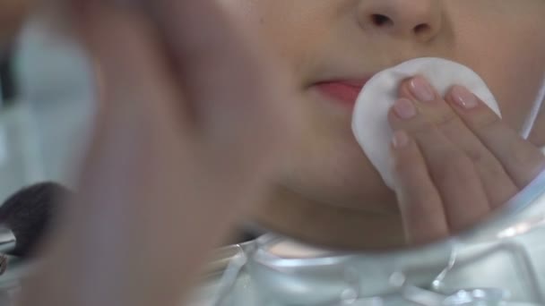 Девочка-подросток вытирает помаду лосьоном и хлопчатобумажным блокнотом, снимает макияж — стоковое видео