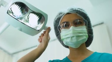 Kadın stomatologist ayarlama diş operasyon ışıklar, muayenesi, hasta Pov