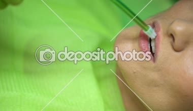 Tükürük dışarı atmak, modern ekipman, closeup ile hijyenik yordamı kullanarak diş hekimi