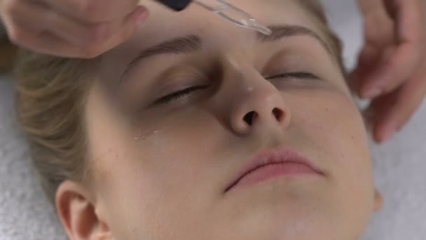 Beauty salon werknemer toepassing hydraterende olie en masseren gezicht, spaservice — Stockvideo