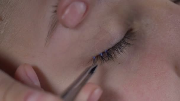 Schoonheidsspecialiste valse wimpers met cosmetische lijm in oog hoek, glamour toe te passen — Stockvideo