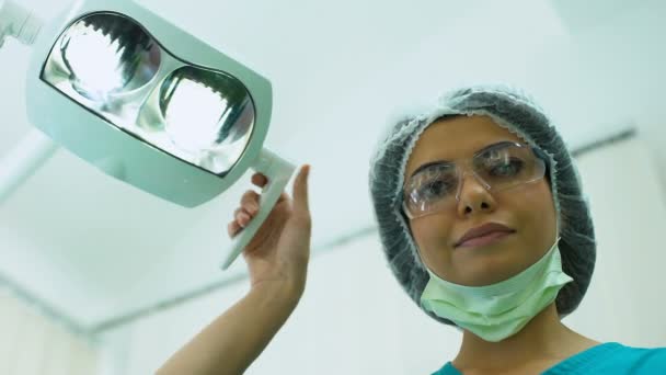Cirurgião ajustando a iluminação antes da operação, cirurgia plástica, cosmetologia — Vídeo de Stock