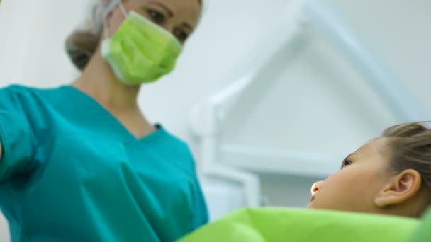 Dentista pediátrico perfurando dente doente para menina, paciente corajoso sorrindo — Vídeo de Stock