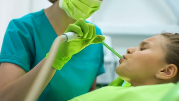 Estomatólogo usando eyector de saliva, niño paciente sonriendo, cliente satisfecho — Vídeo de stock