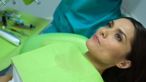 Stomatologist preparing dental tools, calm patient waiting, routine checkup — Stock Video