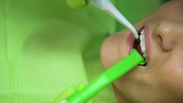 Dentista lavaggio dei denti paziente dopo la procedura di sbiancamento, cure dentistiche, primo piano — Video Stock