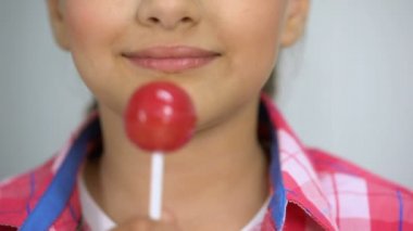 Küçük kız zevk lolipop, mutlu çocukluk kavramı, diş sağlığı, portre