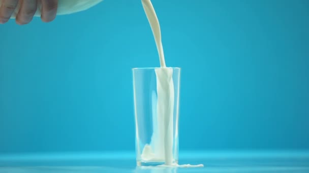 Hand pouring milk in glass on table, healthy nutrition, dairy product, breakfast — Stock Video