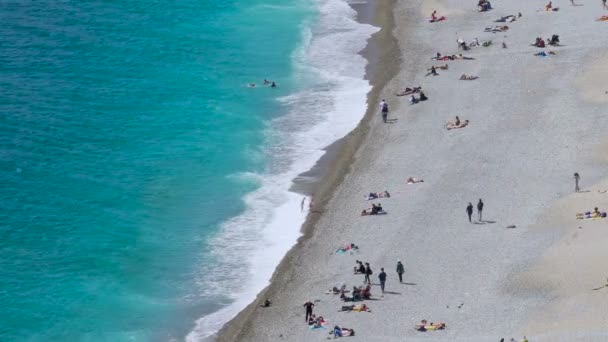 Туристи загоряти і відпочиваючи на пляжі в Ніцці, літній туризм і відпочинок — стокове відео