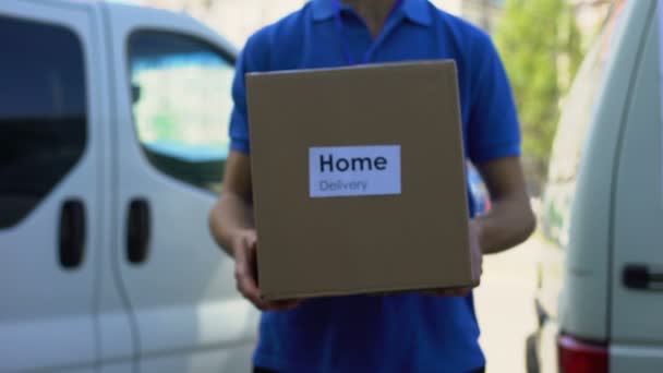 Levering aan huis service courier in uniform holding kartonnen doos, express verzending — Stockvideo