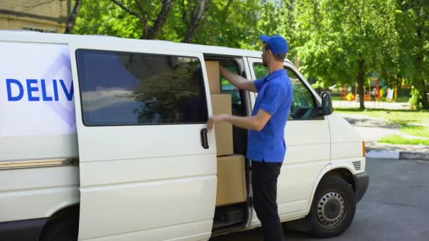 Доставщик забирает посылку из фургона, курьерской компании, транспортной фирмы — стоковое видео