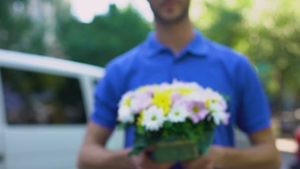 Mensageiro masculino mostrando presente de flores, serviço de entrega florística, surpresa romântica — Vídeo de Stock