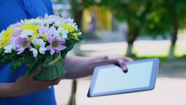 Cliente da empresa de entrega anexando assinatura no tablet e recebendo flores — Vídeo de Stock