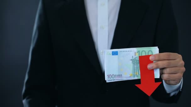 Фінансовий експерт, який тримає банкноти євро, показує великі пальці вгору і вниз, падає — стокове відео