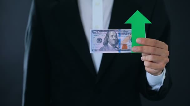 Финансовый консультант с банкнотами в долларах, показывающими большие пальцы вверх и вниз, рост — стоковое видео