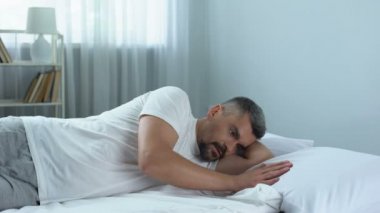 Üzgün yakışıklı adam yavaşça yanına, boşanma sonrası yalnızlık yastık okşayarak