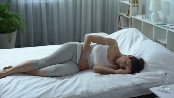 junge Frau leidet unter starken Schmerzen und Krämpfen im Unterbauch, Menstruation