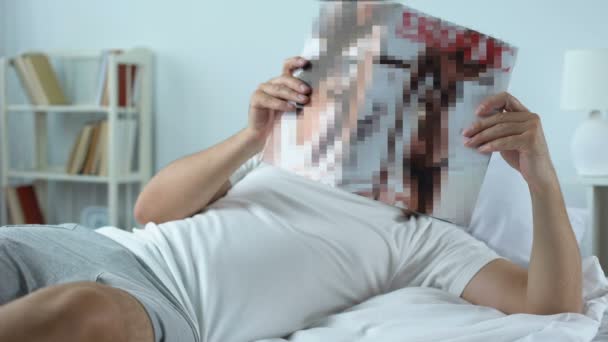 Ember az ágyban fekve, és felnőtt tartalom vizsgálata a magazin, agglegények szabadidő — Stock videók