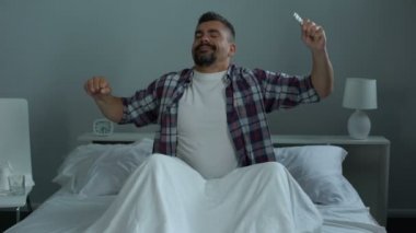 Kendini enerjik hissediyor adam yatakta biyolojik olarak aktif katkı maddeleri, alarak