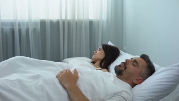 Чоловік хропіння в ліжку, роздратована дружина прокидається і штовхає чоловіка, проблема зі здоров'ям — стокове відео
