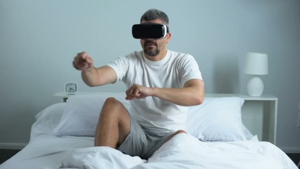 Человек, проходящий квест в наушниках виртуальной реальности, современные технологии, времяпрепровождение дома — стоковое видео