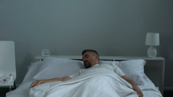 Zieke man in bed zetten nasale druppels in neus en behandeling ziekte van in slaap vallen — Stockvideo