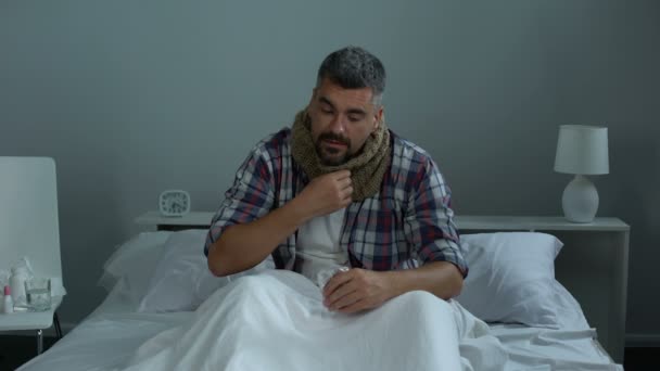 Mężczyzna w łóżku, cierpienie, ból gardła, biorąc leki przeciwwirusowe, epidemia grypy — Wideo stockowe