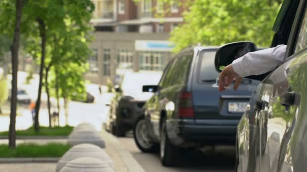 Man parkeren auto, roken en gooien stub op straat, milieu vervuiling — Stockvideo