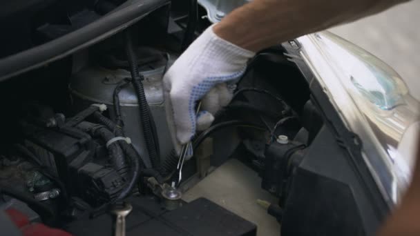 Monteur reparatie automotoren, tot vaststelling van de auto batterij, breuk onder motorkap — Stockvideo