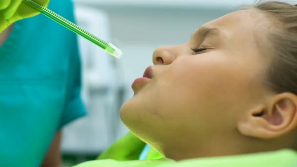 Estomatólogo retirando la saliva de la pequeña boca del paciente con succión dental — Vídeos de Stock