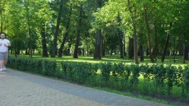 Şişman adam yavaş yavaş açık havada, obezite ile mücadele olarak aktif yaşam tarzı çalışan