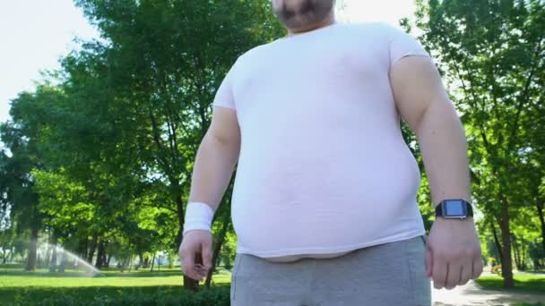 Uomo obeso monitoraggio battito cardiaco su smartwatch dopo il jogging, app per la sanità — Video Stock