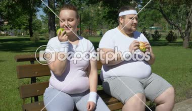 Obez adam yeme hamburger, elma, önemsiz ya da sağlıklı gıda seçimine hayran şişman kız