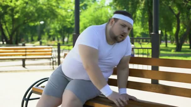 Ожирение человек чувствует боковые боли после напряженных тренировок на открытом воздухе, проблемы со здоровьем — стоковое видео