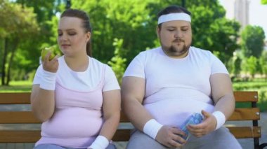 Egzersiz ve diyet, adam üzgün obez kız şişman çift bankta, Erkek zorlar
