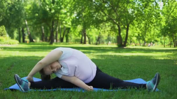 Chica obesa haciendo splits, ejercicios de fitness al aire libre, manera de estilo de vida saludable — Vídeos de Stock