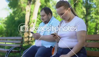 Obez çift, gönderme fotoğraflar sosyal ağ için bekleyen üzgün kız seviyor