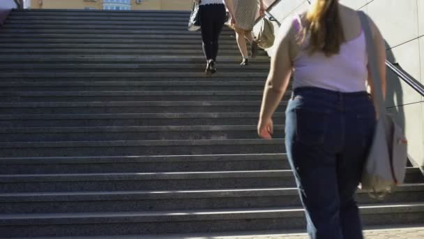 Жирная пара, идущая вместе по лестнице, проблемы избыточного веса среди молодежи — стоковое видео