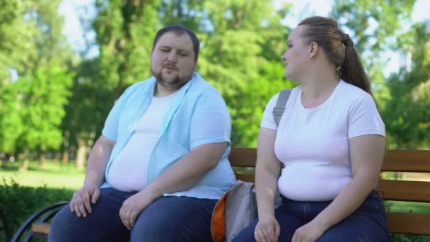 博学的肥胖的人讲有趣的故事对俏丽的女孩, 自信 — 图库视频影像