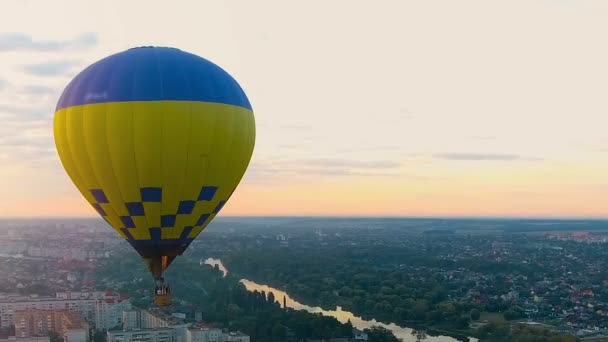 Flyg luftballong mot solnedgången över staden, holiday underhållning — Stockvideo