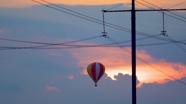 Повітряна куля летить на тлі заходу сонця, хмарне небо, незвичайна подорож — стокове відео