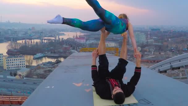 Gymnastice dvojice provádějící akrobatické cvičení na vrcholu mostu, důvěra v partnera — Stock video