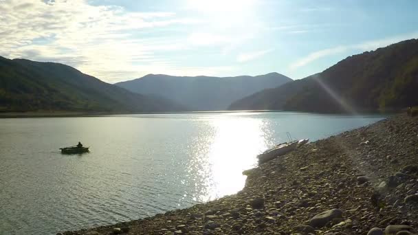 Bateau à rames homme sur le lac dans les hauts plateaux, unité avec la nature, harmonie de méditation — Video