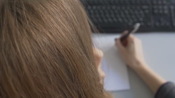 Vrouwelijke officemanager praten over telefoon, op die zijn doen notities op papier over verkooporder — Stockvideo