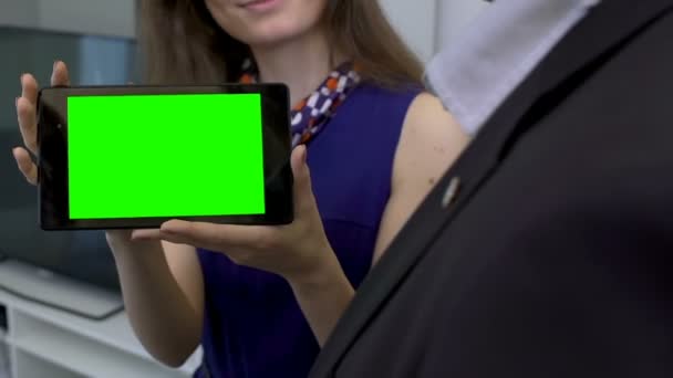 Agente de viagens acessível mostrando ao tablet cliente com ofertas especiais, tela verde — Vídeo de Stock